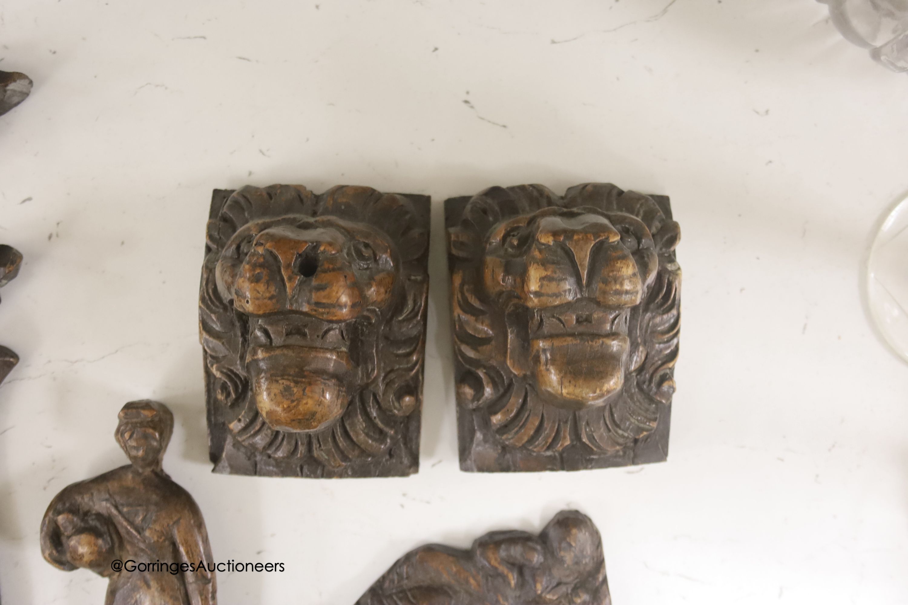 Seven 17th century or later carved oak fragments including a pair of lion masks